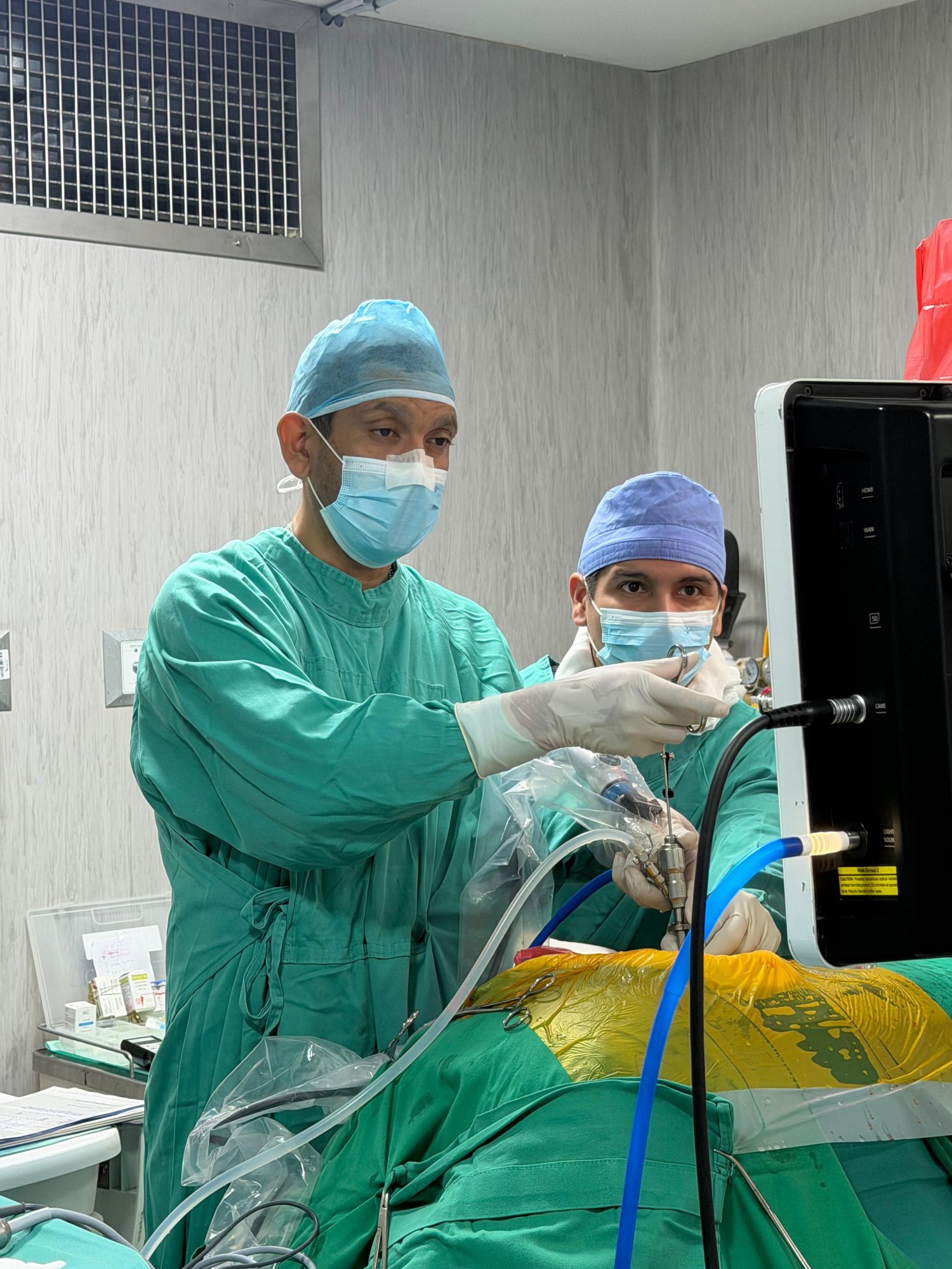 Dr. José León señalando el monitor durante una cirugía endoscópica