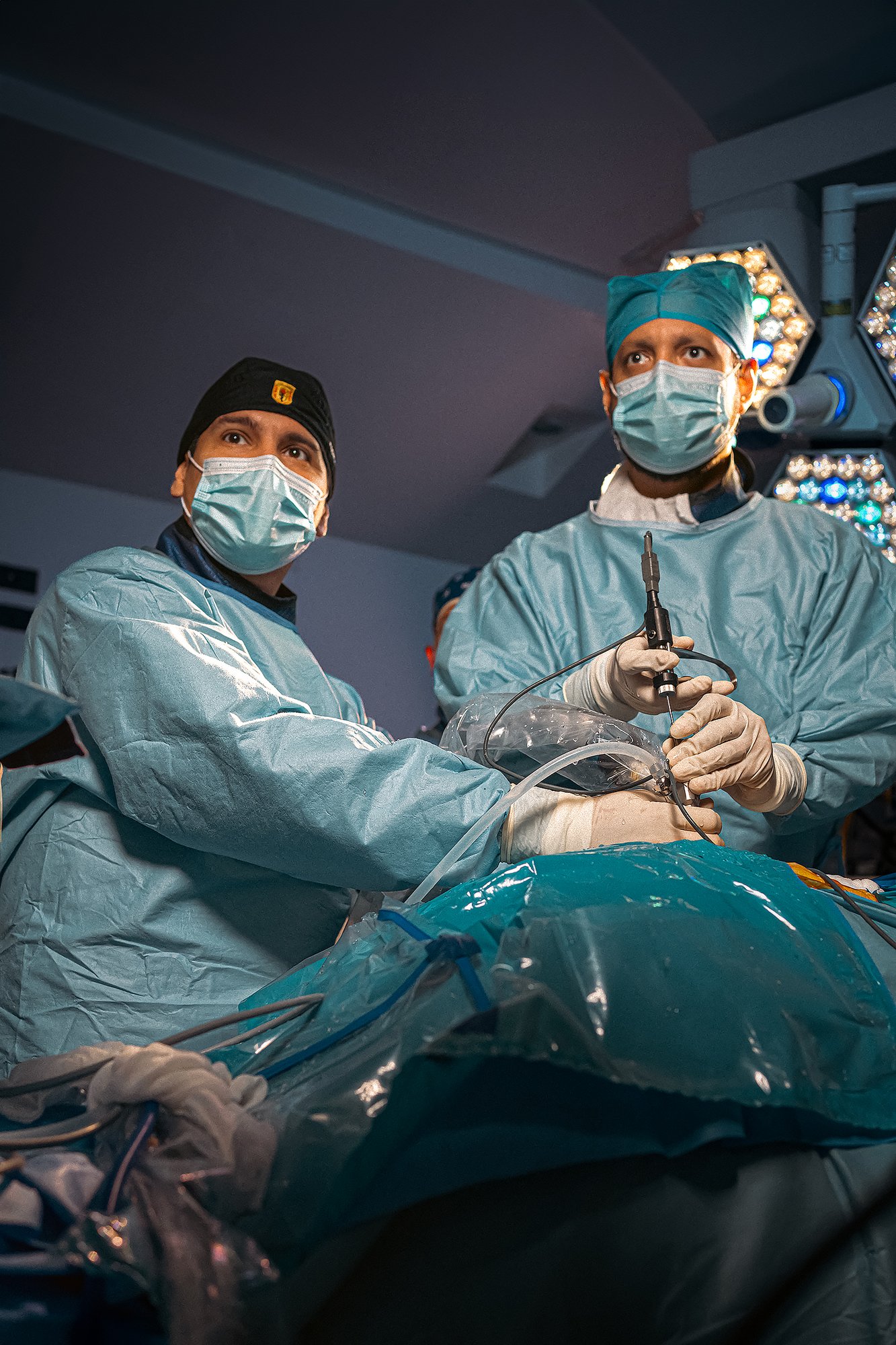 Dos cirujanos operando con técnica endoscópica en quirófano